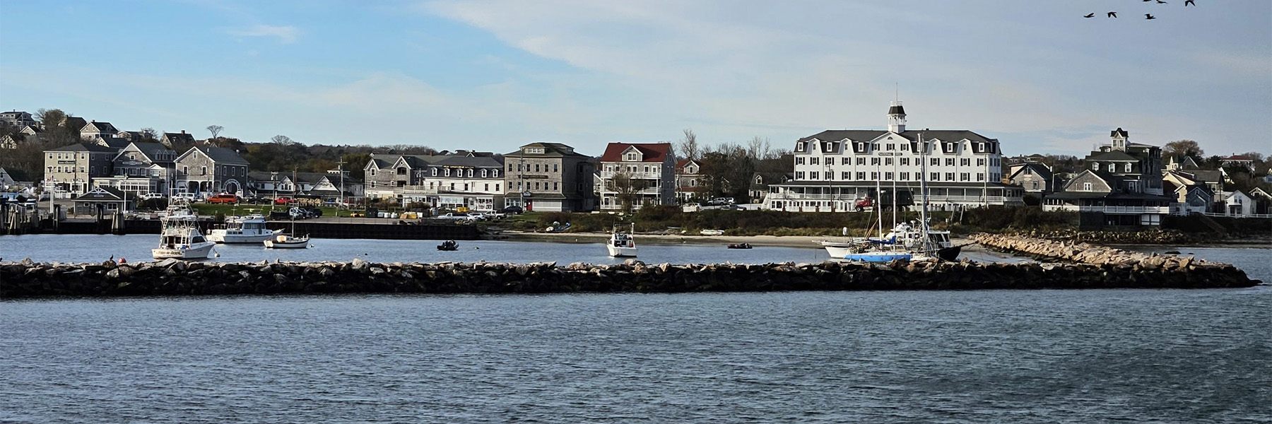 Shoreham Harbor on Block Island. Boats in the foreground with buildings along the shore.