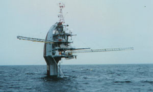 FLIP, a ship which can be partially submerged to form a 
fixed instrument platform, is shown in its buoy position 
supporting masts of instruments.