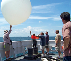 Scientists aboard the NOAA Ship Ronald H. Brown deploying a research balloon carrying an ozonesonde—which measures ozone in the atmosphere—that rises up to 70,000 feet and sends back the data to ground stations.