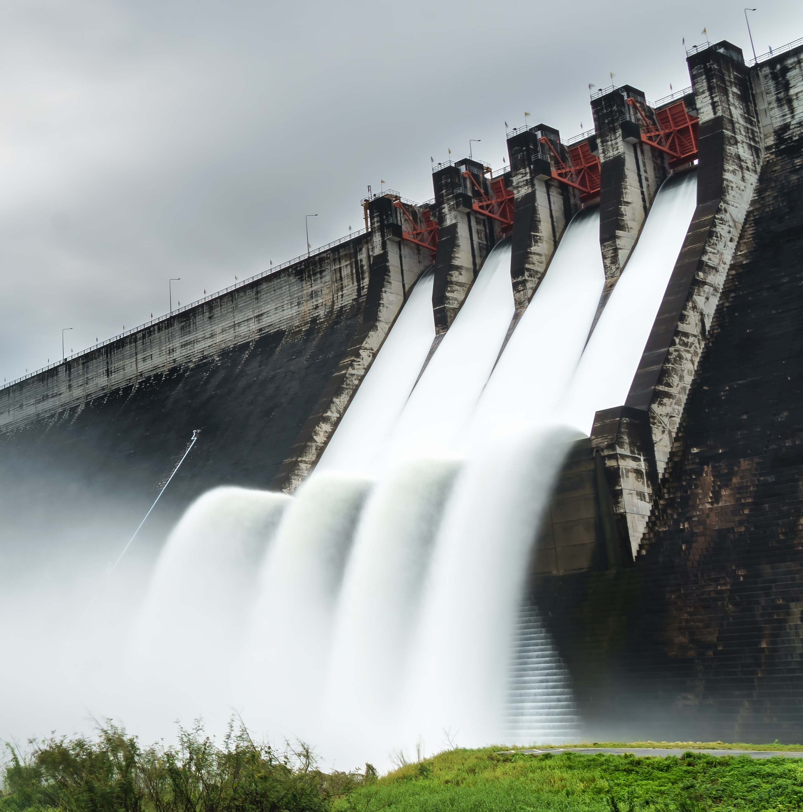 a dam overflows with water into its spillway